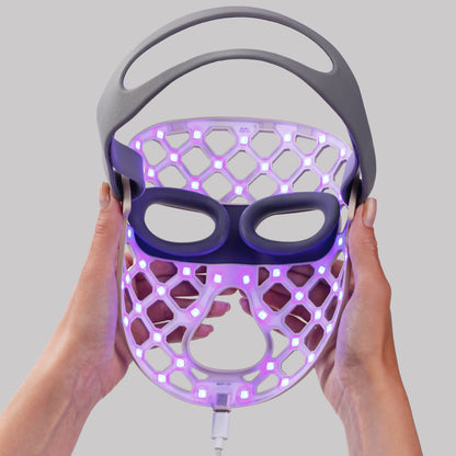 Women holding the LED face mask with blue light